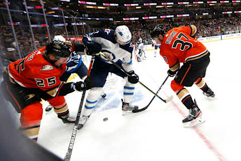 ANAHEIM, CALIFORNIA – NOVEMBER 29: Nick Ritchie #37 and Ondrej Kase #25 of the Anaheim Ducks battle Adam Lowry #17 of the Winnipeg Jets for a loose puck during the first period of a game at Honda Center on November 29, 2019, in Anaheim, California. (Photo by Sean M. Haffey/Getty Images)