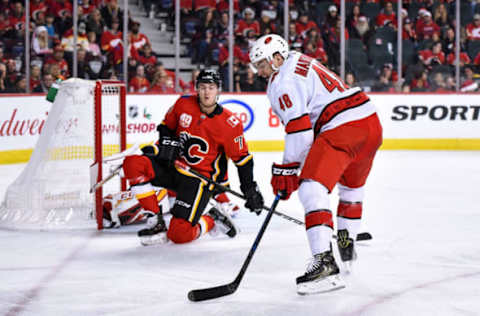 CALGARY, AB – DECEMBER 14: Carolina Hurricanes Center Jordan Martinook (48) tries to shoot the puck as Calgary Flames Center Mark Jankowski (77) and Calgary Flames Goalie David Rittich (33) try to defend their goal during the first period of an NHL game where the Calgary Flames hosted the Carolina Hurricanes on December 14, 2019, at the Scotiabank Saddledome in Calgary, AB. (Photo by Brett Holmes/Icon Sportswire via Getty Images)