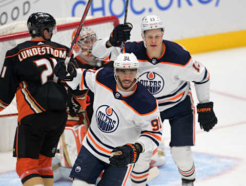 Apr 3, 2022; Anaheim, California, USA; Edmonton Oilers right wing Jesse Puljujarvi (13) and left wing Evander Kane (91) celebrate after a goal is scored by defenseman Tyson Barrie (22) past Anaheim Ducks goaltender John Gibson (36) in the first period of the game at Honda Center. Mandatory Credit: Jayne Kamin-Oncea-USA TODAY Sports