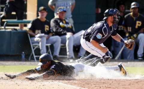 Mar 1, 2016; Lakeland, FL, USA; Pittsburgh Pirates shortstop Alen Hanson (59) slides safely into home as Detroit Tigers catcher Bryan Holaday (50) catches the throw during the seventh inning at Joker Marchant Stadium. Mandatory Credit: Butch Dill-USA TODAY Sports