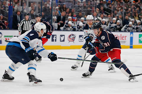 Feb 16, 2023; Columbus, Ohio, USA; Columbus Blue Jackets left wing Kent Johnson (91) avoids the check of Winnipeg Jets defenseman Neal Pionk (4) during the second period at Nationwide Arena. Mandatory Credit: Russell LaBounty-USA TODAY Sports