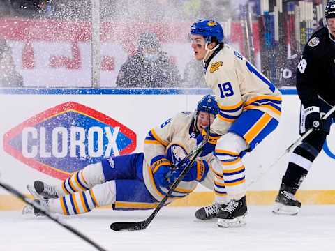 Mar 13, 2022; Hamilton, Ontario, CAN; Buffalo Sabres forward Peyton Krebs (19) skates past a falling Buffalo Sabres defenseman Robert Hagg (8) during the third period against the Toronto Maple Leafs in the 2022 Heritage Classic ice hockey game at Tim Hortons Field. Mandatory Credit: John E. Sokolowski-USA TODAY Sports