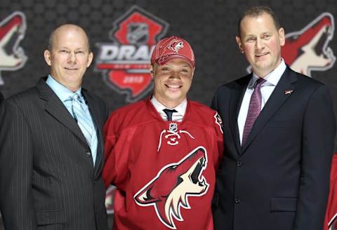 Jun 30, 2013; Newark, NJ, USA; Max Domi poses for a photo with team officials after being introduced as the number twelve overall pick to the Phoenix Coyotes during the 2013 NHL Draft at the Prudential Center. Mandatory Credit: Ed Mulholland-USA TODAY Sports