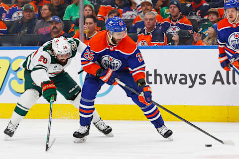 Dec 8, 2023; Edmonton, Alberta, CAN; Minnesota Wild forward Pat Maroon (20) tries to knock the puck away from Edmonton Oilers defensemen Darnell Nurse (25) during the second period at Rogers Place. Mandatory Credit: Perry Nelson-USA TODAY Sports