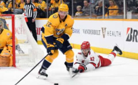 Apr 6, 2023; Nashville, Tennessee, USA; Nashville Predators defenseman Tyson Barrie (22) takes the puck from Carolina Hurricanes center Jesperi Kotkaniemi (82) during the second period at Bridgestone Arena. Mandatory Credit: Christopher Hanewinckel-USA TODAY Sports