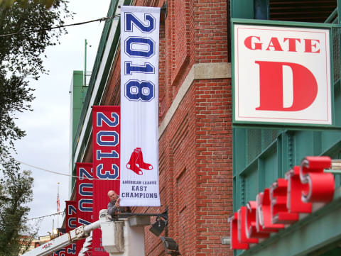 BOSTON – SEPTEMBER 21: Joe Gravell makes a final adjustment as the Boston Red Sox 2018 American League East division championship banner is hung outside of Fenway Park in Boston on Sep. 21, 2018. (Photo by David L. Ryan/The Boston Globe via Getty Images)