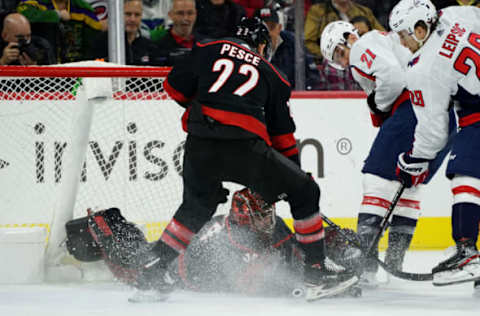 RALEIGH, NC – JANUARY 3: Petr Mrazek #34 of the Carolina Hurricanes goes down in the crease to make a save as Brett Pesce #22 defends, and Brendan Leipsic #28 of the Washington Capitals looks for a rebound during an NHL game on January 3, 2020, at PNC Arena in Raleigh, North Carolina. (Photo by Gregg Forwerck/NHLI via Getty Images)