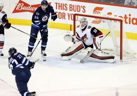 Jan 26, 2016; Winnipeg, Manitoba, CAN; Winnipeg Jets left wing Nikolaj Ehlers (27) scores his third goal to complete the hat trick during the second period against Arizona Coyotes goalie Louis Domingue (35) at MTS Centre. Mandatory Credit: Bruce Fedyck-USA TODAY Sports