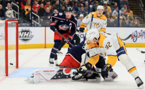 Oct 20, 2022; Columbus, Ohio, USA; Columbus Blue Jackets goaltender Elvis Merzlikins (back) attempts a save as Nashville Predators center Ryan Johansen (92) scores a goal in the first period at Nationwide Arena. Mandatory Credit: Aaron Doster-USA TODAY Sports