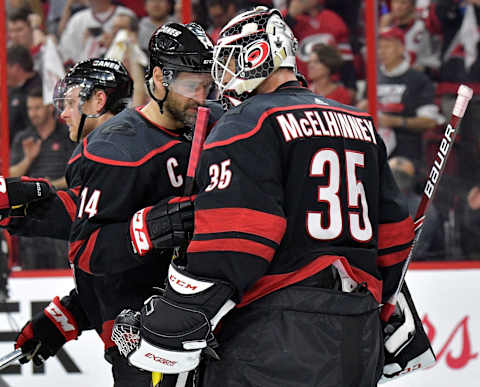 RALEIGH, NORTH CAROLINA – MAY 03: Justin Williams #14 has a quiet word with Curtis McElhinney #35 of the Carolina Hurricanes after a win against the New York Islanders in Game Four of the Eastern Conference Second Round during the 2019 NHL Stanley Cup Playoffs at PNC Arena on May 03, 2019 in Raleigh, North Carolina. The Hurricanes won 5-2 and won the series, 4-0. (Photo by Grant Halverson/Getty Images)