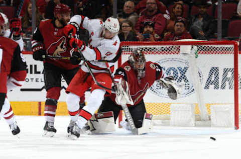 GLENDALE, ARIZONA – FEBRUARY 06: Goalie Antti Raanta #32 of the Arizona Coyotes looks to cover the puck as Warren Foegele #13 of the Carolina Hurricanes and Alex Goligoski #33 of the Coyotes battle in front of the net during the first period of the NHL hockey game at Gila River Arena on February 06, 2020 in Glendale, Arizona. (Photo by Norm Hall/NHLI via Getty Images)