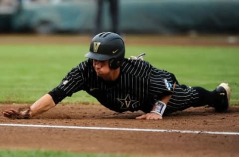 Jun 14, 2015; Omaha, NE, USA; Vanderbilt Commodores outfielder Bryan Reynolds (20) slides back into first base against the Cal State Fullerton Titans in the second inning in the 2015 College World Series at TD Ameritrade Park. Mandatory Credit: Steven Branscombe-USA TODAY Sports