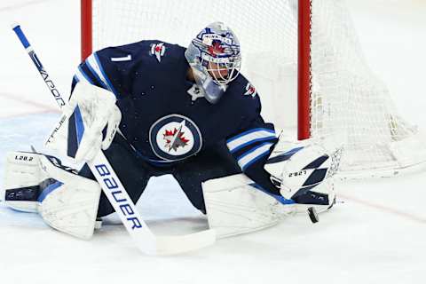 Apr 27, 2022; Winnipeg, Manitoba, CAN; Winnipeg Jets goalie Eric Comrie (1) makes a save on a shot by Philadelphia Flyers forward Zack MacEwen (17) during the third period at Canada Life Centre. Mandatory Credit: Terrence Lee-USA TODAY Sports