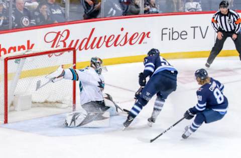 WINNIPEG, MB – MARCH 12: Goaltender Aaron Dell #30 of the San Jose Sharks slides across the crease to make a stop on Tyler Myers #57 of the Winnipeg Jets during third period action at the Bell MTS Place on March 12, 2019 in Winnipeg, Manitoba, Canada. The Sharks defeated the Jets 5-4. (Photo by Jonathan Kozub/NHLI via Getty Images)