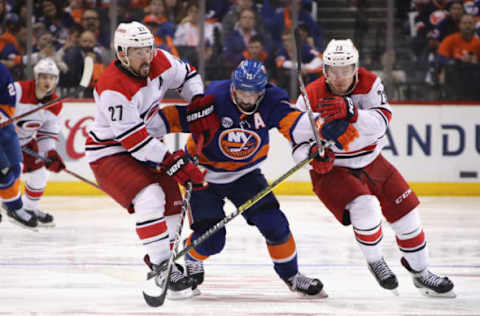 NEW YORK, NEW YORK – APRIL 26: Justin Faulk #27 and Brock McGinn #23 of the Carolina Hurricanes hold up Cal Clutterbuck #15 of the New York Islanders in Game One of the Eastern Conference Second Round during the 2019 NHL Stanley Cup Playoffs at the Barclays Center on April 26, 2019 in the Brooklyn borough of New York City. (Photo by Bruce Bennett/Getty Images)