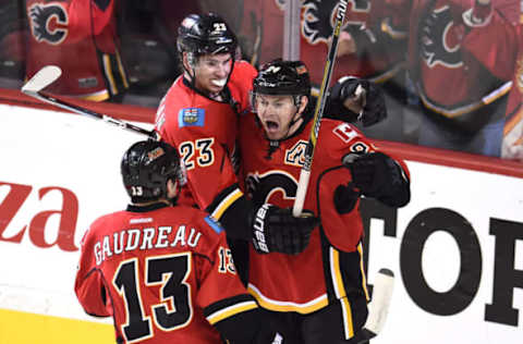 Apr 25, 2015; Calgary, Alberta, CAN; Calgary Flames center Jiri Hudler (24) center Sean Monahan (23) and left wing Johnny Gaudreau (13) celebrate Hudler’s third period goal against the Vancouver Canucks in game six of the first round of the 2015 Stanley Cup Playoffs at Scotiabank Saddledome. Flames won 7-4. Mandatory Credit: Candice Ward-USA TODAY Sports