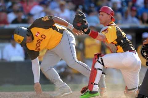 Jul 10, 2016; San Diego, CA, USA; World infielder Josh Naaylor (left) is tagged out by USA catcher Carson Kelly in the 6th inning during the All Star Game futures baseball game at PetCo Park. Mandatory Credit: Gary A. Vasquez-USA TODAY Sports