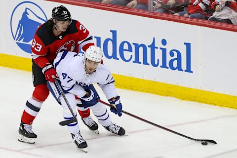 Feb 1, 2022; Newark, New Jersey, USA; Toronto Maple Leafs left wing Pierre Engvall (47) skates with the puck past New Jersey Devils defenseman Ryan Graves (33) during the third period at Prudential Center. Mandatory Credit: Tom Horak-USA TODAY Sports