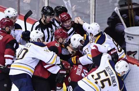 Jan 18, 2016; Glendale, AZ, USA; Arizona Coyotes left wing Anthony Duclair (10) and right wing Shane Doan (19) and left wing Mikkel Boedker (89) fight with Buffalo Sabres defenseman Zach Bogosian (47), and left wing Marcus Foligno (82) and defenseman Rasmus Ristolainen (55) as NHL linesman Darren Gibbs (66) tries to break them up after the conc;usion of the game at Gila River Arena. Mandatory Credit: Matt Kartozian-USA TODAY Sports