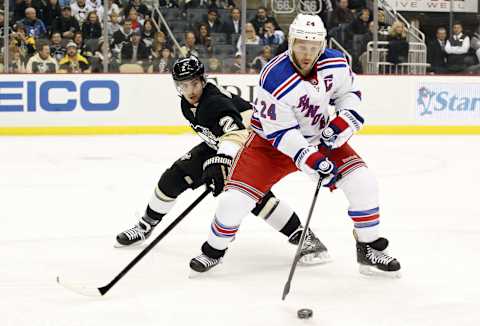 Jan 3, 2014; Pittsburgh, PA, USA; New York Rangers right-wing Ryan Callahan (24) reaches for the puck as Pittsburgh Penguins defenseman Matt Niskanen (2) defends during the first period at the CONSOL Energy Center. Mandatory Credit: Charles LeClaire-USA TODAY Sports