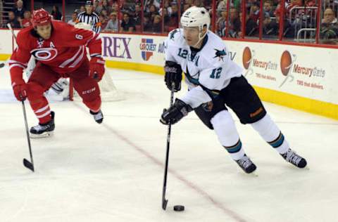 RALEIGH, NC – DECEMBER 06: Patrick Marleau #12 of the San Jose Sharks skates with the puck against Tim Gleason #6 of the Carolina Hurricanes at PNC Arena on December 6, 2013 in Raleigh, North Carolina. The Hurricanes defeated the Sharks 5-3. (Photo by Lance King/Getty Images)