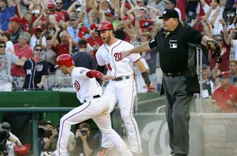 Jun 12, 2016; Washington, DC, USA; Washington Nationals right fielder Bryce Harper (34) and shortstop Danny Espinosa (8) celebrate after scoring the game winning runs against the Philadelphia Phillies at Nationals Park. The Washington Nationals won 5-4. Mandatory Credit: Brad Mills-USA TODAY Sports