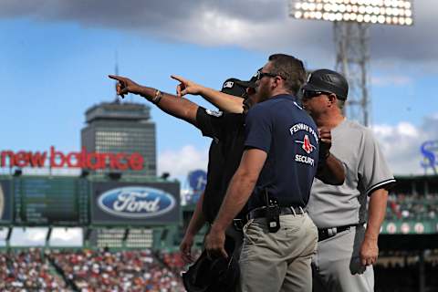 BOSTON, MA – SEPTEMBER 29: The on field umpiring crew point out the fan who threw a home run ball back on the field striking New York Yankees designated hitter Giancarlo Stanton (27) during the seventh inning. The Boston Red Sox host the New York Yankees in Game 2 of a three game series at Fenway Park in Boston, MA on Sept. 29, 2018. (Photo by Barry Chin/The Boston Globe via Getty Images)