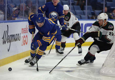 Oct 16, 2021; Buffalo, New York, USA; Buffalo Sabres defenseman Will Butcher (4) skates behind the net with the puck as Arizona Coyotes left wing Johan Larsson (22) defends during the first period at KeyBank Center. Mandatory Credit: Timothy T. Ludwig-USA TODAY Sports