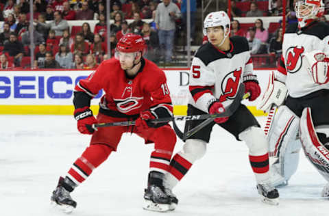 RALEIGH, NC – APRIL 04: Carolina Hurricanes Left Wing Warren Foegele (13) goes to the front of the net with New Jersey Devils Defenceman Connor Carrick (5) during a game between the New Jersey Devils and the Carolina Hurricanes at the PNC Arena in Raleigh, NC on April 4, 2019. (Photo by Greg Thompson/Icon Sportswire via Getty Images)