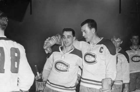 Canadian professional ice hockey players goalie Jacques Plante (1929 – 1986) (left) and Butch Bouchard of the Montreal Canadiens stand with their arms around each other on the ice, mid 1950s. (Photo by Bruce Bennett Studios/Getty Images)