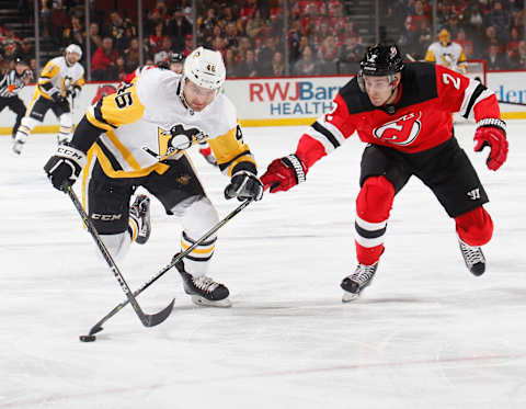 Zachary Aston-Reese #46 of the Pittsburgh Penguins skates after the puck as John Moore #2 of the New Jersey Devils defends (Photo by Paul Bereswill/Getty Images)