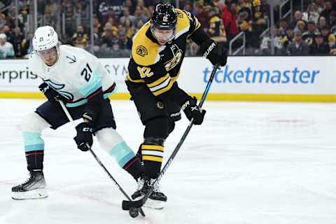 BOSTON, MASSACHUSETTS – JANUARY 12: Craig Smith #12 of the Boston Bruins and Alex Wennberg #21 of the Seattle Kraken battle for control of the puck during the first period at TD Garden on January 12, 2023, in Boston, Massachusetts. (Photo by Maddie Meyer/Getty Images)