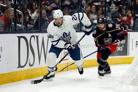 COLUMBUS, OH – FEBRUARY 22: Ilya Lyubushkin #26 of the Toronto Maple Leafs skates the puck away from Oliver Bjorkstrand #28 of the Columbus Blue Jackets during the game at Nationwide Arena on February 22, 2022 in Columbus, Ohio. (Photo by Kirk Irwin/Getty Images)