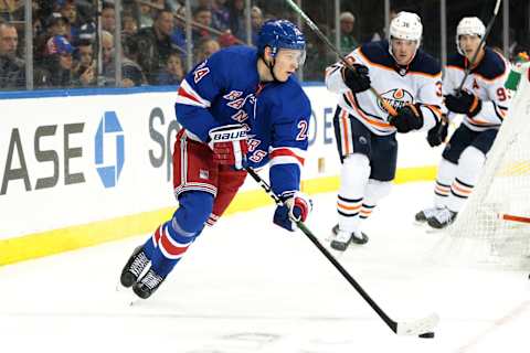 Oct 12, 2019; New York, NY, USA; New York Rangers right wing Kaapo Kakko (24) skates with the puck in front of Edmonton Oilers defenseman Joel Persson (36) during the second period against the Edmonton Oilers at Madison Square Garden. Mandatory Credit: Vincent Carchietta-USA TODAY Sports