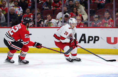 CHICAGO, ILLINOIS – NOVEMBER 03: Sebastian Aho #20 of the Carolina Hurricanes skates against Reese Johnson #52 of the Chicago Blackhawks during the first period at United Center on November 03, 2021, in Chicago, Illinois. (Photo by Stacy Revere/Getty Images)