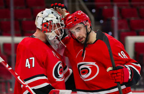 Feb 15, 2021; Raleigh, North Carolina, USA; Carolina Hurricanes center Cedric Paquette (18) and goaltender James Reimer (47) celebrate their win against the Columbus Blue Jackets at PNC Arena. Mandatory Credit: James Guillory-USA TODAY Sports