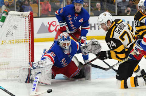 BOSTON, MA – MARCH 27: Henrik Lundqvist #30 of the New York Rangers reaches for the puck against Jake DeBrusk #74 of the Boston Bruins at the TD Garden on March 27, 2019 in Boston, Massachusetts. (Photo by Steve Babineau/NHLI via Getty Images)