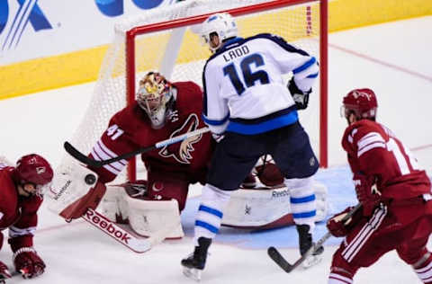 Oct 9, 2014; Glendale, AZ, USA; Arizona Coyotes goalie Mike Smith (41) makes a save on Winnipeg Jets left wing Andrew Ladd (16) during the first period at Gila River Arena. Mandatory Credit: Matt Kartozian-USA TODAY Sports