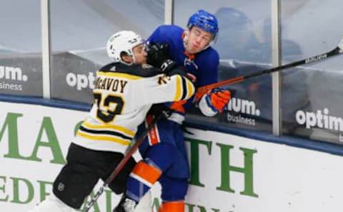 Mar 9, 2021; Uniondale, New York, USA; Boston Bruins defenseman Charlie McAvoy (73) checks New York Islanders left wing Anthony Beauvillier (R) into the boards during the first period at Nassau Veterans Memorial Coliseum. Mandatory Credit: Andy Marlin-USA TODAY Sports