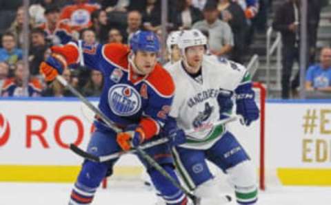 Oct 8, 2016; Edmonton, Alberta, CAN; Edmonton Oilers forward Milan Lucic (27) and Vancouver Canucks forward Jannik Hansen (36) battle for a loose puck during the first period of a preseason hockey game at Rogers Place. Mandatory Credit: Perry Nelson-USA TODAY Sports