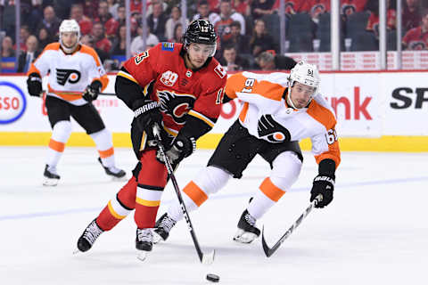 Oct 15, 2019; Calgary, Alberta, CAN; Calgary Flames left wing Johnny Gaudreau (13) battles for the puck with Philadelphia Flyers defenseman Justin Braun (61) during the first period at Scotiabank Saddledome. Flames won 3-1. Mandatory Credit: Candice Ward-USA TODAY Sports