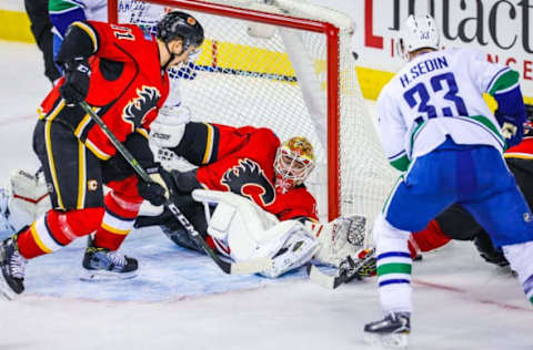 Dec 23, 2016; Calgary, Alberta, CAN; Calgary Flames goalie Brian Elliott (1) makes a save as Vancouver Canucks center Henrik Sedin (33) tries to score during the third period at Scotiabank Saddledome. Calgary Flames won 4-1. Mandatory Credit: Sergei Belski-USA TODAY Sports