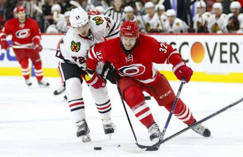 Jan 26, 2016; Raleigh, NC, USA; Carolina Hurricanes forward Kris Versteeg (32) tries to control the puck against Chicago Blackhawks forward Artemi Panarin (72) during the second period at PNC Arena. Mandatory Credit: James Guillory-USA TODAY Sports