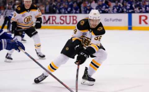 Nov 15, 2019; Toronto, Ontario, CAN; Boston Bruins defenseman Urho Vaakanainen (58) tries to control the puck against the Toronto Maple Leafs at Scotiabank Arena. Boston defeated Toronto. Mandatory Credit: John E. Sokolowski-USA TODAY Sports