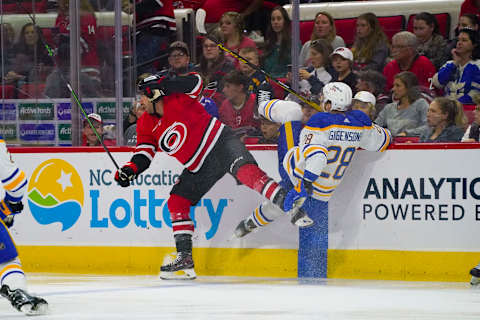 Apr 7, 2022; Raleigh, North Carolina, USA; Carolina Hurricanes left wing Jordan Martinook (48) hits Buffalo Sabres left wing Zemgus Girgensons (28) during the first period at PNC Arena. Mandatory Credit: James Guillory-USA TODAY Sports