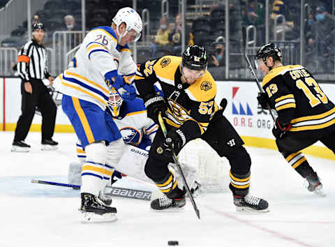 May 1, 2021; Boston, Massachusetts, USA; Boston Bruins center Sean Kuraly (52) tries to gain control of the puck while Buffalo Sabres defenseman Rasmus Dahlin (26) defends during the second period at TD Garden. Mandatory Credit: Bob DeChiara-USA TODAY Sports