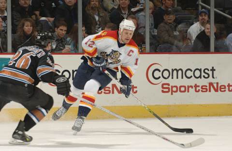 WASHINGTON – FEBRUARY 7: Center Olli Jokinen #12 of the Florida Panthers looks to make a pass around defenseman Shaone Morrisonn #26 of the Washington Capitals during their NHL game on February 7, 2006 at MCI Center in Washington, DC. The Panthers won 5-0. (Photo by Mitchell Layton/Getty Images)