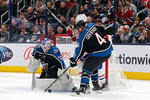 Nov 23, 2022; Columbus, Ohio, USA; Columbus Blue Jackets defenseman Vladislav Gavrikov (4) clears the puck from a Columbus Blue Jackets goalie Joonas Korpisalo (70) save against the Montreal Canadiens during the second period at Nationwide Arena. Mandatory Credit: Russell LaBounty-USA TODAY Sports