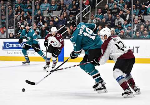 SAN JOSE, CA – APRIL 06: Joe Thornton #19 of the San Jose Sharks skates ahead with the puck against Tyson Jost #17 of the Colorado Avalanche at SAP Center on April 06, 2019 in San Jose, California (Photo by Brandon Magnus/NHLI via Getty Images)