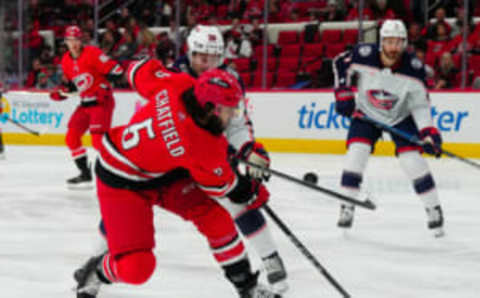 Nov 26, 2023; Raleigh, North Carolina, USA; Carolina Hurricanes defenseman Jalen Chatfield (5) shot is blocked by Columbus Blue Jackets left wing Eric Robinson (50) during the first period at PNC Arena. Mandatory Credit: James Guillory-USA TODAY Sports